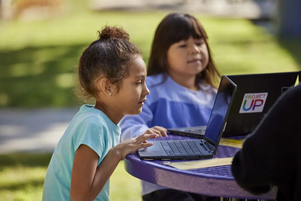 Students on laptops as a part of Comcast's Project UP program to support digital learning initiatives. 