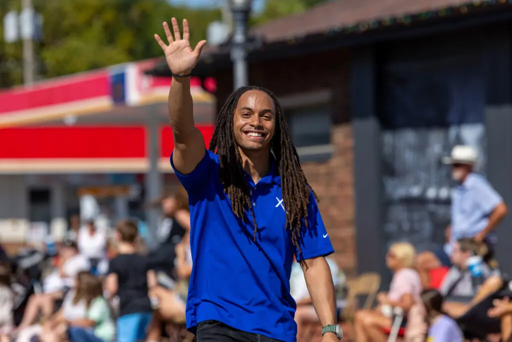 An Xfinity technician walks in local Indiana parade to share info on fast fiber options on behalf of Comcast.