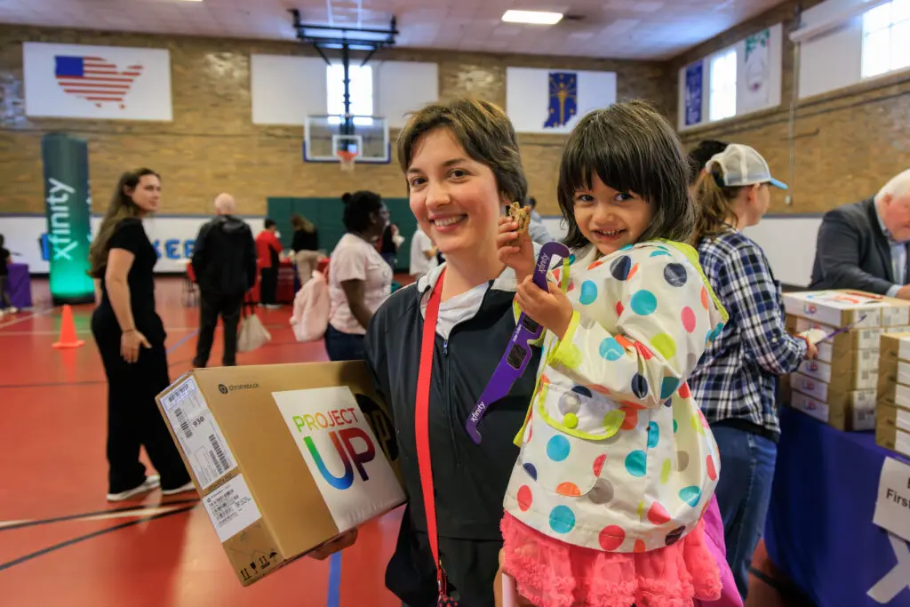 A family attends Comcast Project UP event to bridge the digital divide and leave with laptop donation.