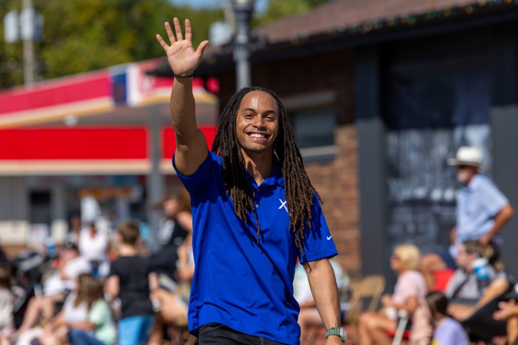 An Xfinity technician walks in local Indiana parade to share info on fast fiber options on behalf of Comcast.